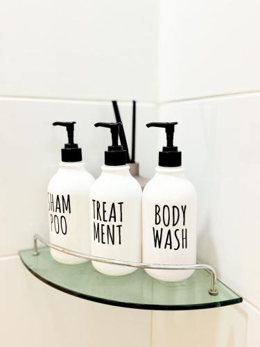 three bottles of soap on a glass shelf in a bathroom at Sum Leisure Gocheok Dome 6 minutes Emotional 4-person two-room in Seoul
