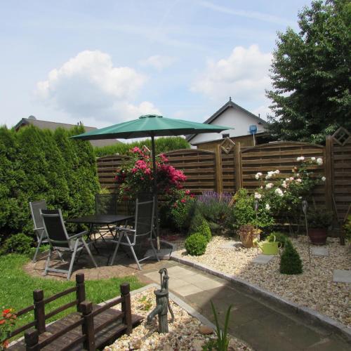 a garden with a table and an umbrella at Eifel Quartier Ferienhaus in Mechernich