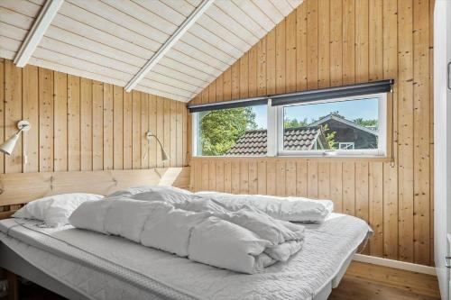 a bed in a wooden room with a window at SB56207-Sydals-Solbjergvej-26 in Sønderby