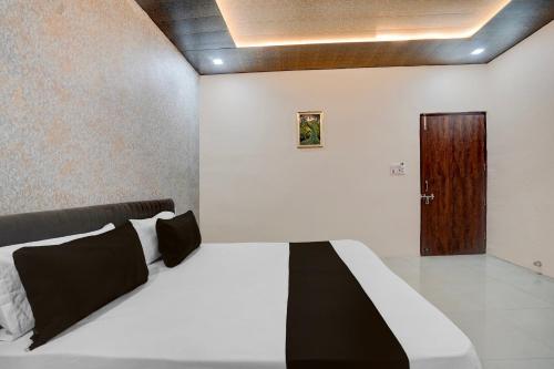 a bedroom with a bed and a wooden door at Hotel O Asthara in Rohtak
