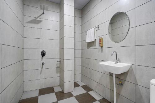 a white bathroom with a sink and a mirror at Hotel O Asthara in Rohtak