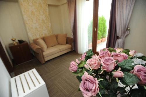 a living room with a bouquet of pink roses at Vurna Butik Hotel in Trabzon