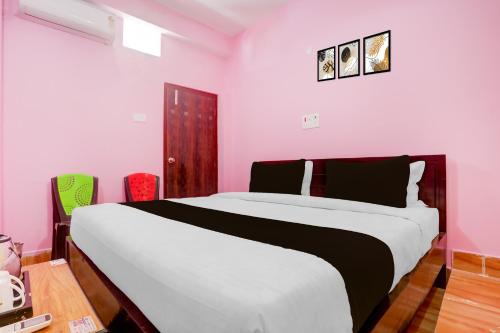 a bedroom with a large bed with pink walls at SPOT ON Hotel Chandi in Bihār Sharīf
