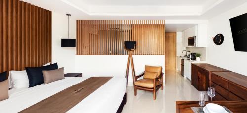 a bedroom with a bed and a table and a chair at Kadun Hotel Boutique in Cabo San Lucas