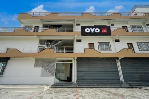 an apartment building with an ovo sign on it at Hotel O Ambari Residency in Kadakola