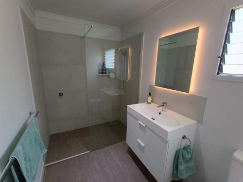 Un baño blanco con lavabo y ducha. en The Property, Tranquil Retreat, 
