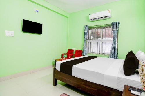 une chambre avec un lit et une télévision au mur dans l'établissement Hotel O SATWIK GUEST HOUSE, à Bhubaneswar