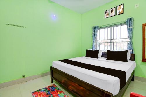 a bedroom with a large bed with a window at Hotel O SATWIK GUEST HOUSE in Khandagiri