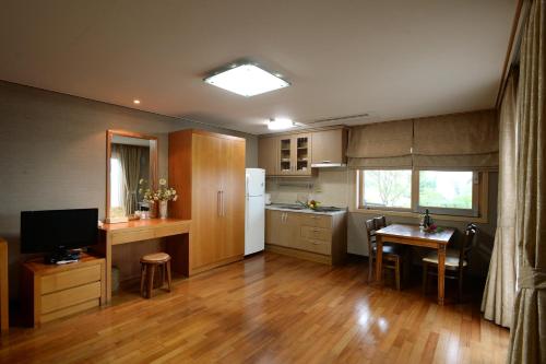 a kitchen with a table and a refrigerator and a dining room at Minitel Soul in Seogwipo