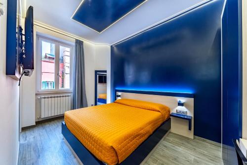 ローマにあるGuesthouse Popの青い部屋にオレンジ色のベッドが備わるベッドルーム1室が備わります。