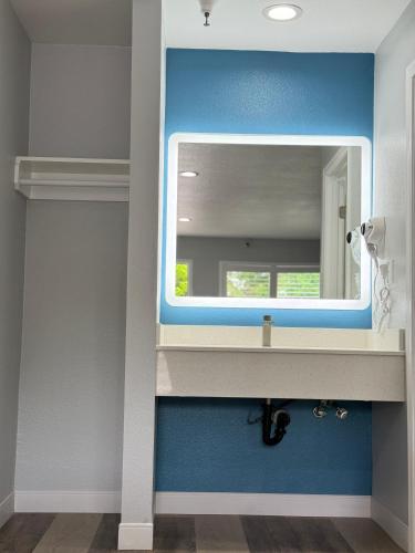 a bathroom with a mirror and a sink at Royale Inn - San Gabriel, Los Angeles in Rosemead
