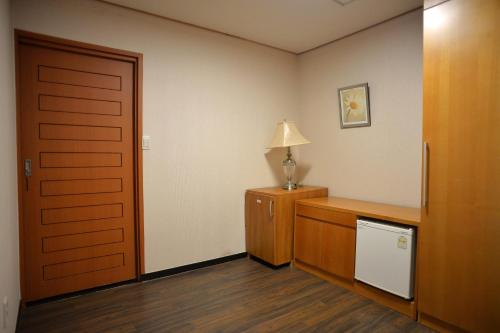 a room with a door and a lamp on a dresser at Minitel Soul in Seogwipo