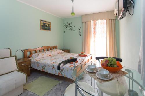 a bedroom with a bed and a table with a bowl of fruit at Djurovic Apartments Montenegro in Kotor