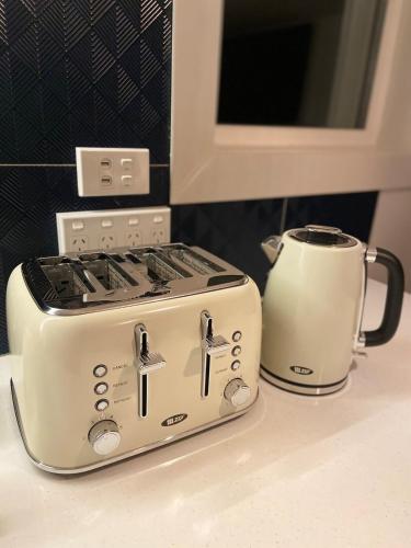 a toaster and a coffee pot on a counter at The Johnsonville Lookout - Bed & Breakfast in Wellington