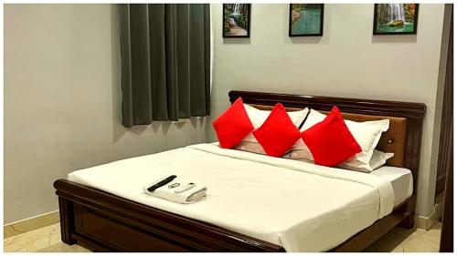 a bedroom with a bed with red pillows at Premium Facilities Hotel R A T R E E - Comfortable and Serene Stay in Bhopal