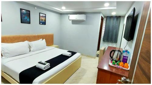 a hotel room with a bed and a television at Premium Facilities Hotel R A T R E E - Comfortable and Serene Stay in Bhopal