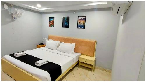 a small room with a bed with white sheets at Premium Facilities Hotel R A T R E E - Comfortable and Serene Stay in Bhopal