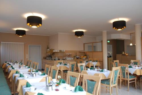 a dining room with white tables and chairs at Apartment Hotel Rüther in Papenburg
