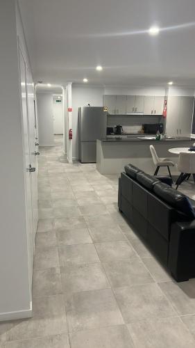 un soggiorno con un divano e un tavolo di Brassall Haven Retreat a Coalfalls