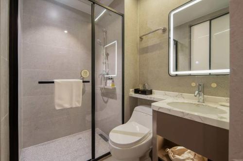 a bathroom with a toilet and a sink and a shower at Rezen Select Hotel (Guangzhou Keyun Road Financial City) in Guangzhou