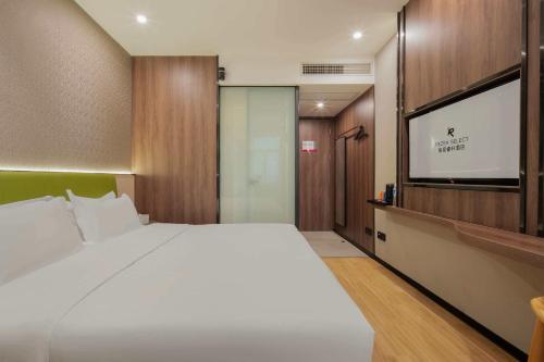 a bedroom with a large bed and a flat screen tv at Rezen Select Hotel (Guangzhou Keyun Road Financial City) in Guangzhou