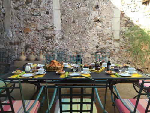 una mesa con comida delante de una pared en Domaine De Brousson, en La Tour-sur-Orb
