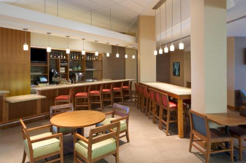 a restaurant with tables and chairs and a bar at Hyatt Place Denver Cherry Creek in Denver