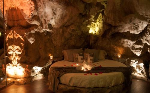 een kamer met een bed in een grot met verlichting bij B&B La Casa nella Roccia in Villanova del Battista