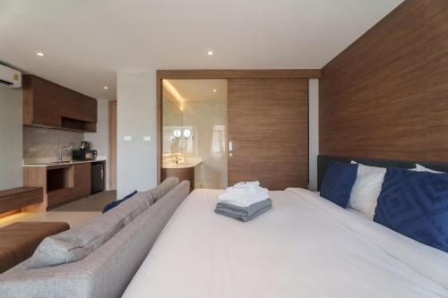 a bedroom with a large white bed and a couch at Wyndham Gardens 1320 Studio 1m from Naithon Beach in Nai Thon Beach