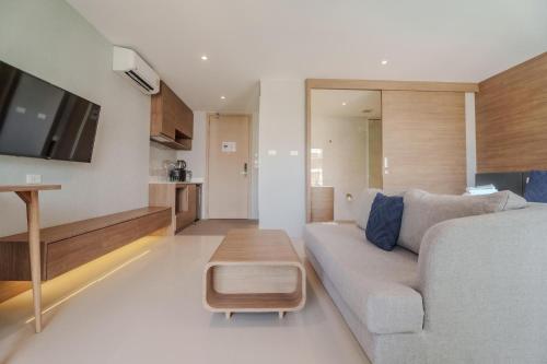 a living room with a couch and a table at Wyndham Gardens 1320 Studio 1m from Naithon Beach in Nai Thon Beach
