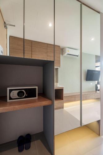 a kitchen with a glass cabinet with a microwave at Wyndham Gardens 1320 Studio 1m from Naithon Beach in Nai Thon Beach
