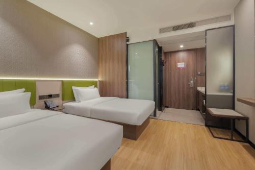 a hotel room with two beds and a desk at Rezen Select Hotel (Guangzhou Keyun Road Financial City) in Guangzhou