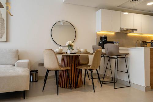 a kitchen with a table with chairs and a mirror at 2BR Luxe Haven - Chic Al Reem Escape in Abu Dhabi