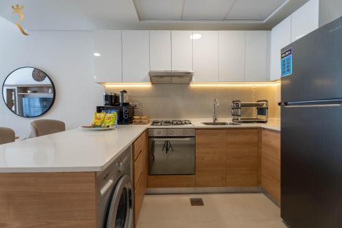 a kitchen with a stainless steel refrigerator and a dishwasher at 2BR Luxe Haven - Chic Al Reem Escape in Abu Dhabi
