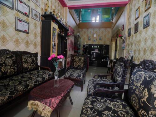 a living room with a couch and chairs and a table at Hotel O Rania Kost Simpang Rimbo in Jambi