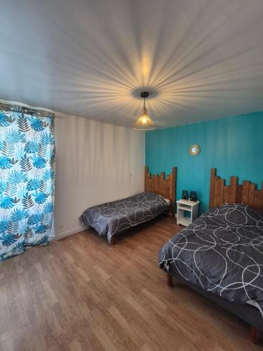 a bedroom with two beds and a ceiling at La plage et le calme in Marennes