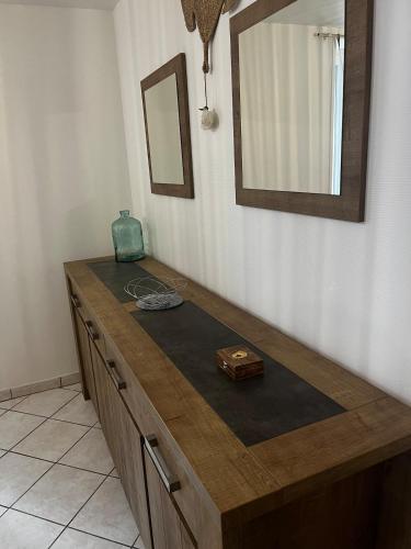 a wooden counter in a room with a mirror at La plage et le calme in Marennes