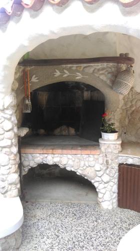 a stone fireplace with a bench in the middle at Apartments Ribica in Rab
