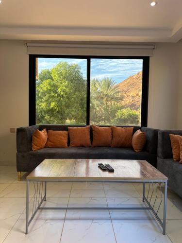 a living room with a couch and a large window at غزال واحد in AlUla
