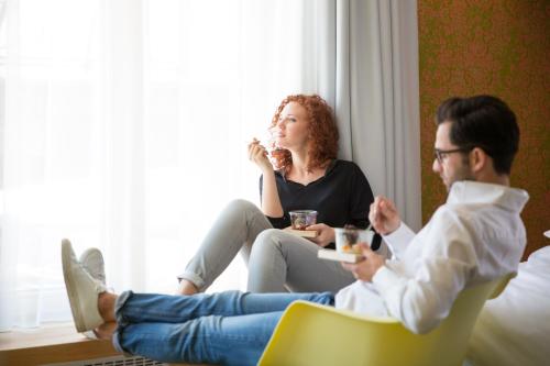 a man and a woman sitting on a couch at Das Freiberg Romantikhotel in Oberstdorf