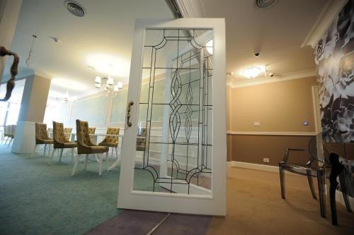 a glass door in a room with a table at Hotel Splendid 1900 in Craiova