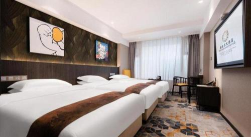 a hotel room with four beds and a flat screen tv at New Friendship Hotel in Luoyang
