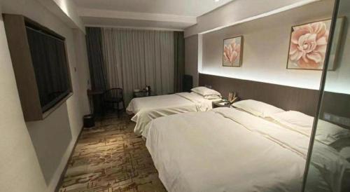a hotel room with two beds and a television at New Friendship Hotel in Luoyang