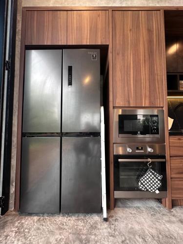 a kitchen with a stainless steel refrigerator and a microwave at Villa AZJA PD in Port Dickson
