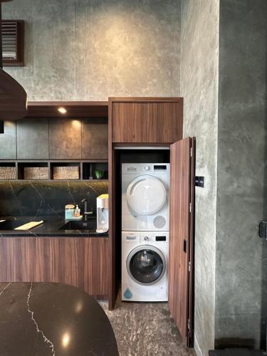 a kitchen with a washing machine in a cabinet at Villa AZJA PD in Port Dickson