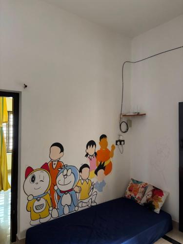a bedroom with a family mural on the wall at Yes Hostel Varkala - Black Beach Road in Varkala