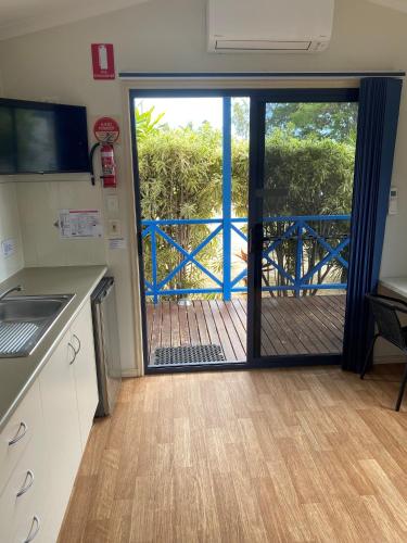 a kitchen with a sliding glass door with a balcony at Bowen Holiday Park in Bowen