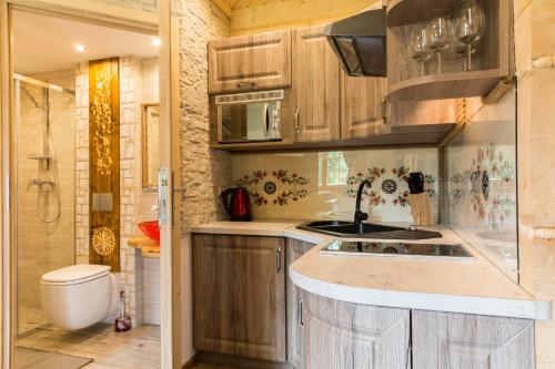a kitchen with wooden cabinets and a sink and a shower at Domek z Widokiem Harenda View in Zakopane