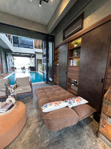 a living room with a couch and a swimming pool at Villa AZJA PD in Port Dickson