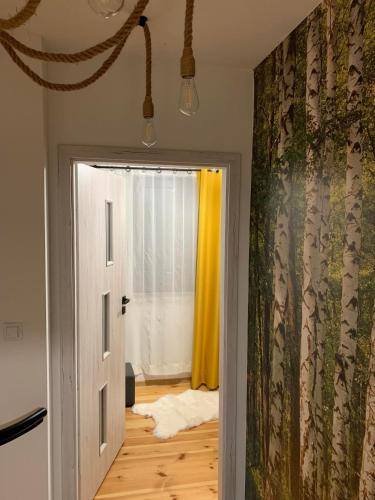 a room with a door and a window with yellow curtains at Domki nad stawem nr2 in Majdan Nowy